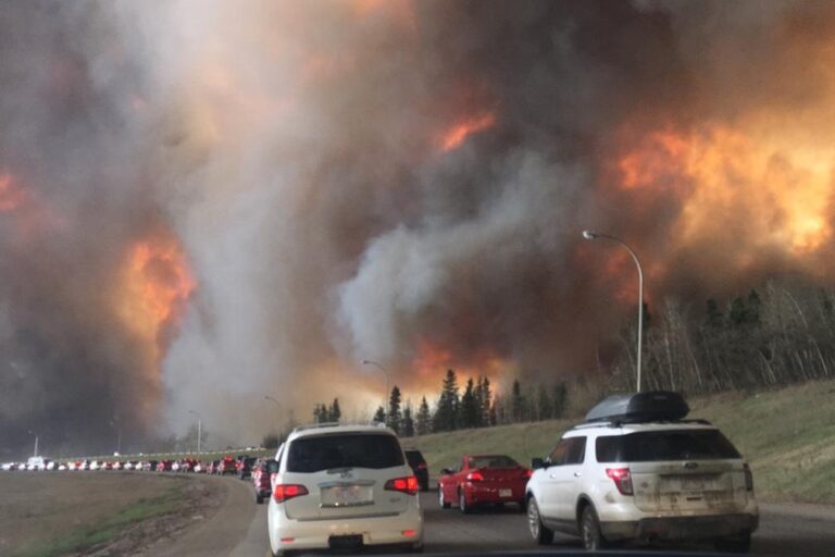 Climate change is already causing misery to billions. Image shows fleeing Fort McMurray fire in 2016